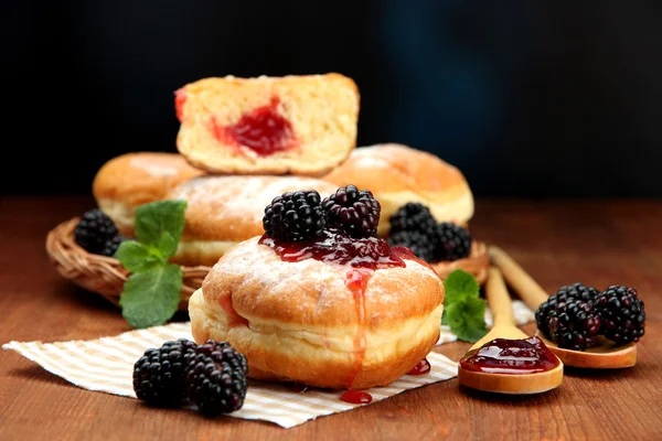 Leckere Donuts mit Beeren auf Holztisch — Stockfoto