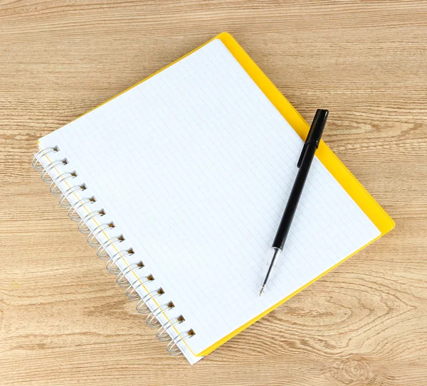 Notebook e caneta na mesa de madeira — Fotografia de Stock