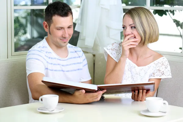 Hermosa pareja romántica joven con foto, en casa — Foto de Stock