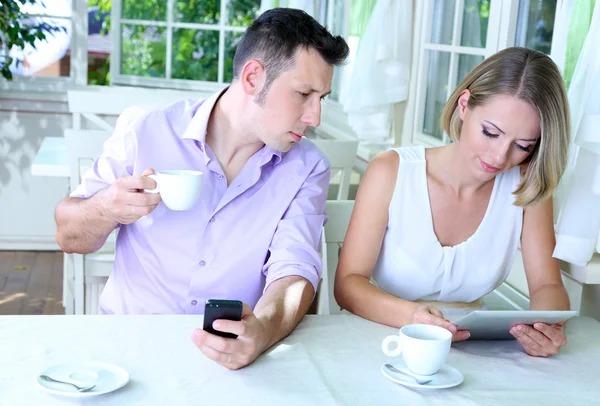 Unga paret tar med tablett i restaurang — Stockfoto