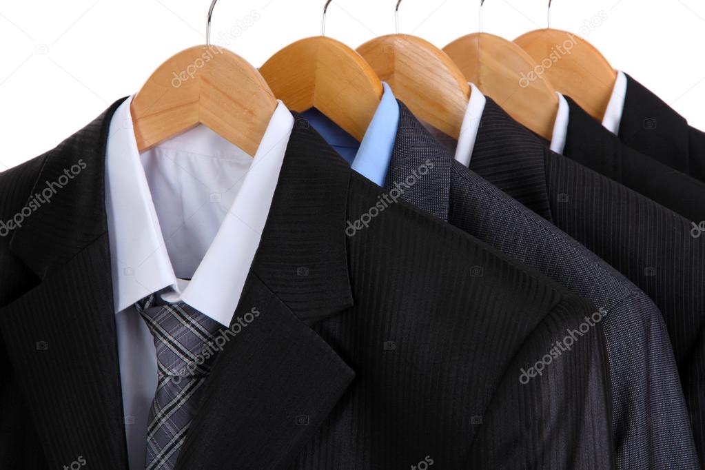 Suits with shirts on hangers on white background