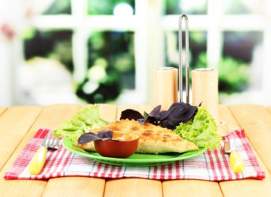 parlak zemin üzerine ahşap masa üzerinde plaka üzerinde taze otlar ile lezzetli chebureks