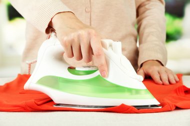 kadın eli parlak arka plan üzerinde elbise Ütü