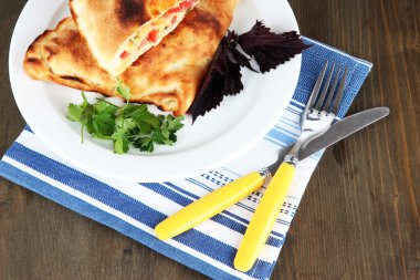 Pizza calzone peçete ahşap masa üzerinde plaka üzerinde