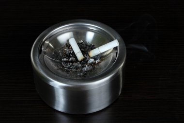 metal kül tablası ile sigara, siyah üzerine izole