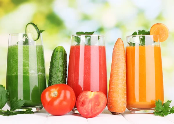 Свежие овощные соки на деревянном столе, на зеленом фоне — стоковое фото