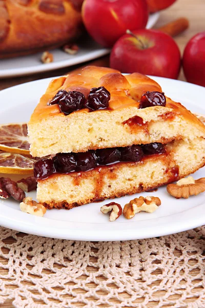 Rebanada de sabroso pastel casero con mermelada y manzanas, en la mesa de madera — Foto de Stock