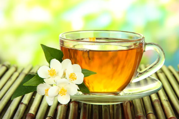 Cup of tea with jasmine, on bamboo mat, close-up — Stock Photo, Image