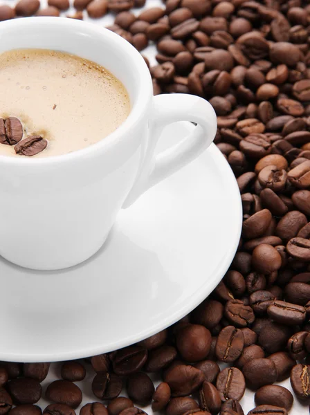 Tasse de café sur fond de grains de café — Photo