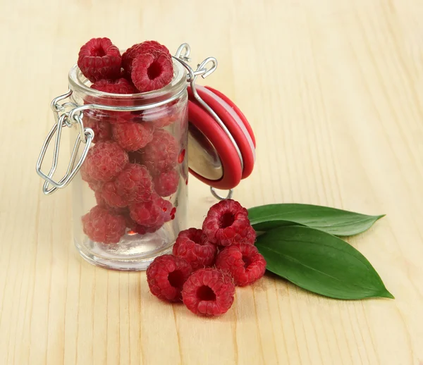 Ripe raspberries in bank on wooden table close-up — Stock Photo, Image