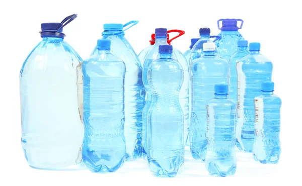 Agua en diferentes botellas aisladas en blanco — Foto de Stock