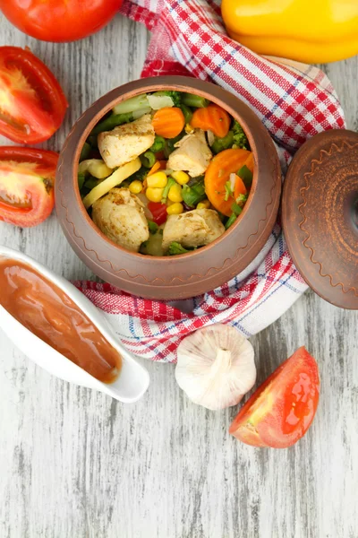 Légumes mélangés cuits au four avec poitrine de poulet en pot, sur fond en bois — Photo