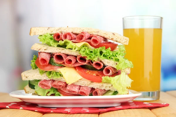Parlak zemin üzerine ahşap masa üzerinde büyük sandviç — Stok fotoğraf