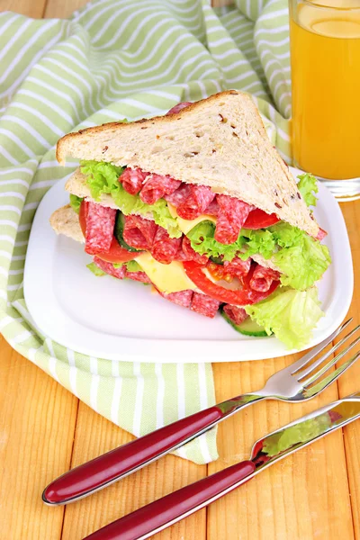 Huge sandwich on wooden table, on wooden background — Stock Photo, Image