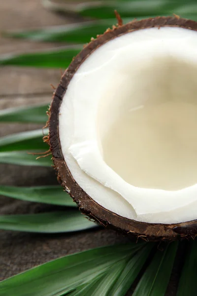 Noce di cocco con foglie, su fondo grigio in legno — Foto Stock