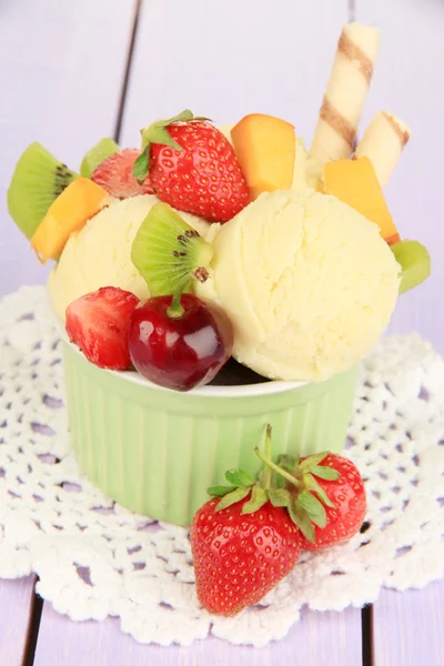 Delicioso helado con frutas y bayas en un tazón sobre una mesa de madera — Foto de Stock