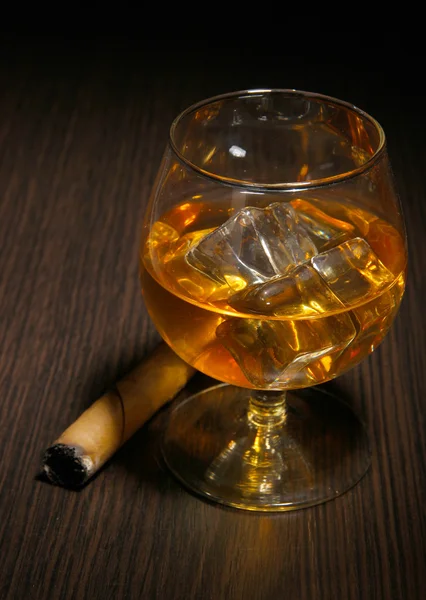 Bicchiere di brandy con ghiaccio su sfondo di legno — Foto Stock