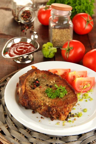 Piece of fried meat on plate on wooden table close-up — Stock Photo, Image