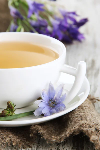 Tasse de thé à la chicorée, sur fond de bois — Photo