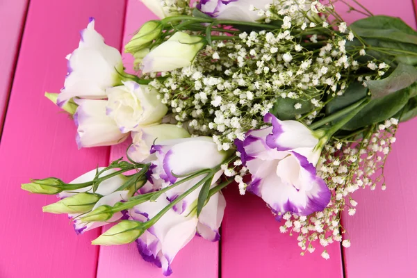 Boeket van eustoma bloemen op een houten achtergrond kleur — Stockfoto