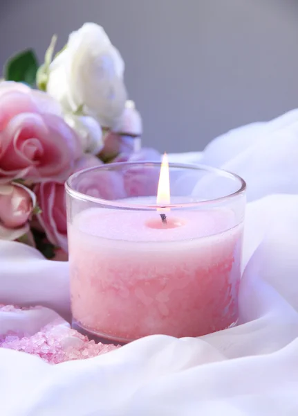 Красива свічка з квіткою на білій тканині, крупним планом — стокове фото