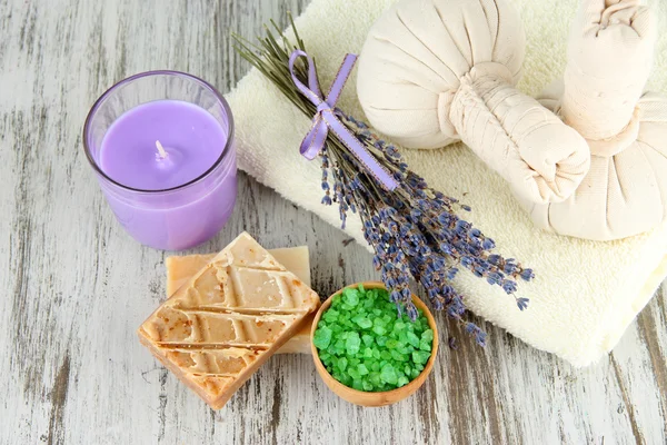Stilleben med lavendel ljus, tvål, massage bollar, tvål och färsk lavendel, på trä bakgrund — Stockfoto