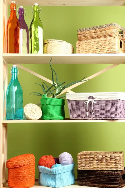 Beautiful white shelves with different home related objects, on color wall background — Stock Photo, Image