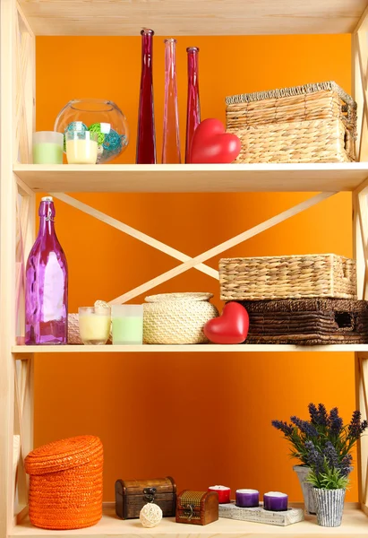 Beautiful white shelves with different home related objects, on color wall background — Stock Photo, Image