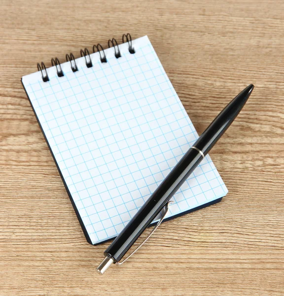 Notebook e caneta na mesa de madeira — Fotografia de Stock