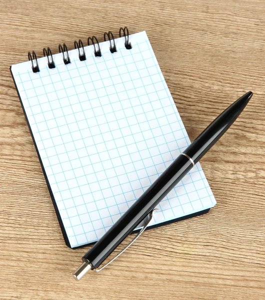 Notebook és toll a fa asztalon — Stock Fotó