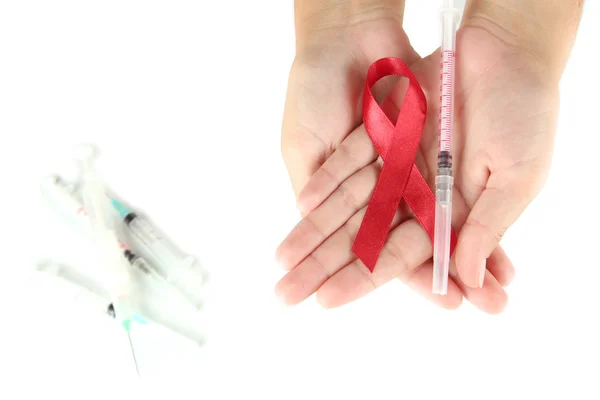 AIDS ribbon and syringes in hands isolated on white — Stock Photo, Image