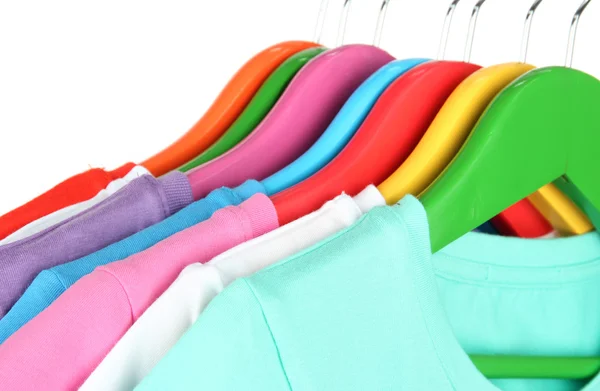 Verschillende shirts op kleurrijke hangers op witte achtergrond — Stockfoto