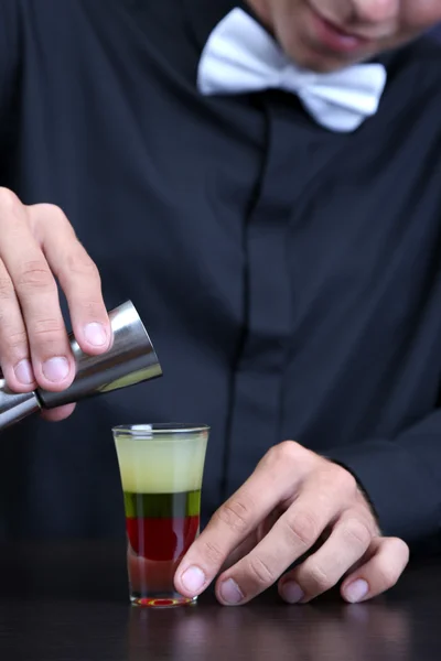 Portrait of handsome barman preparing cocktail, at bar — Stock Photo, Image