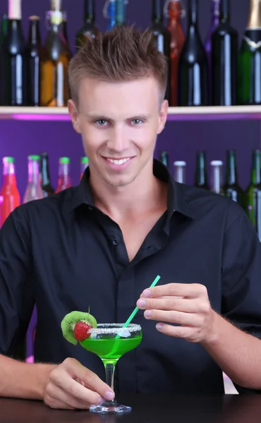 Porträt eines gutaussehenden Barmanns, der an der Bar Cocktails zubereitet — Stockfoto