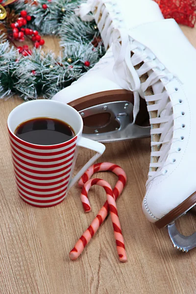 Figure skates with cup of coffee on table close-up — Stock Photo, Image