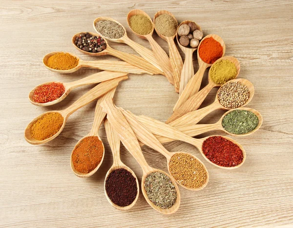 Assortment of spices in wooden spoons on wooden background — Stock Photo, Image