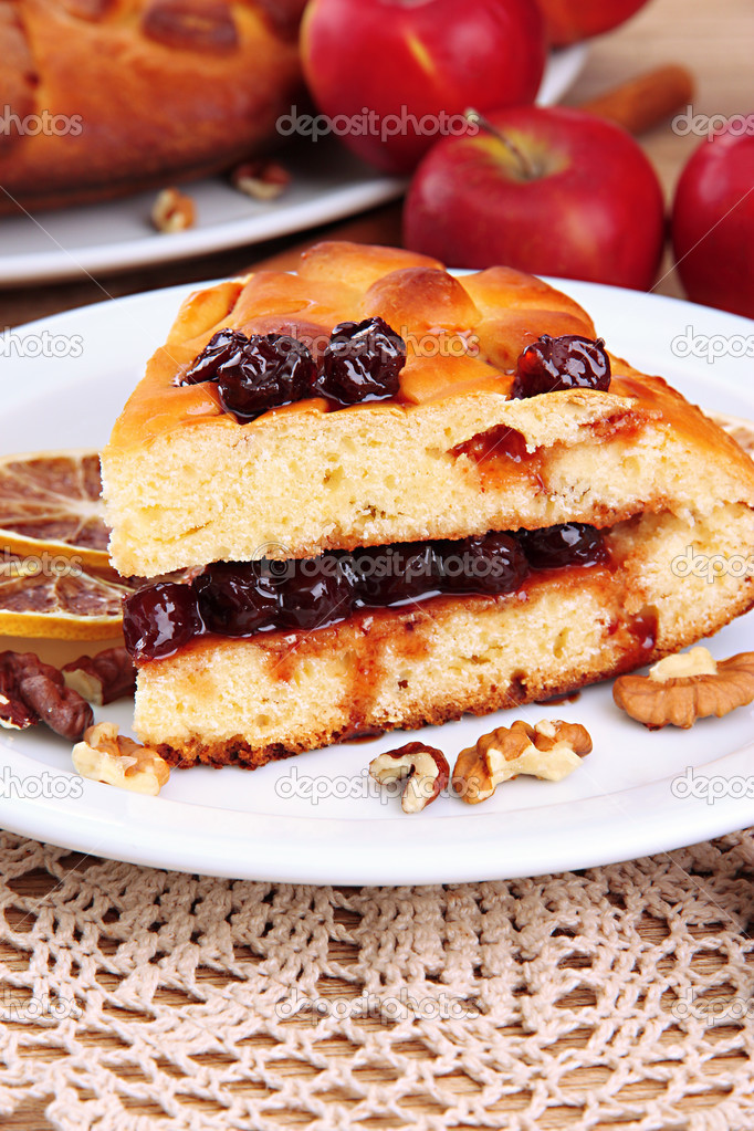 slice of tasty homemade pie with jam and apples, on wooden table