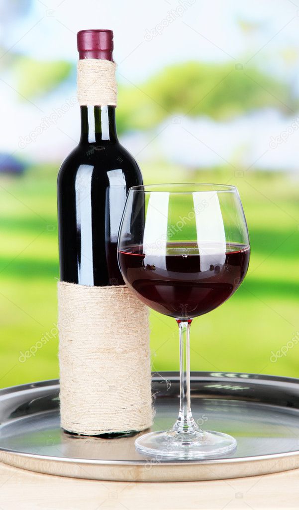 Wine glass and bottle on bright background