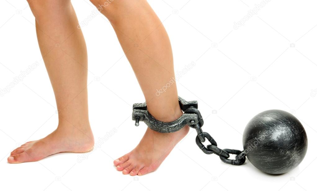Legs in heavy iron shackles isolated on white
