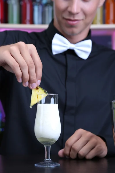 Porträt eines gutaussehenden Barmanns, der an der Bar Cocktails zubereitet — Stockfoto