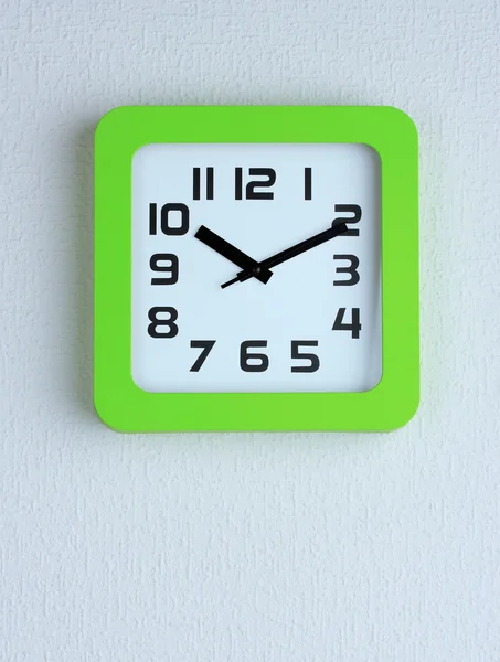 Office clock on color wall background — Stock Photo, Image