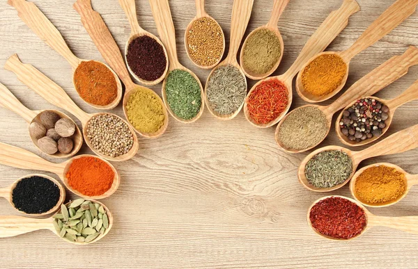 Assortment of spices in wooden spoons on wooden background — Stock Photo, Image