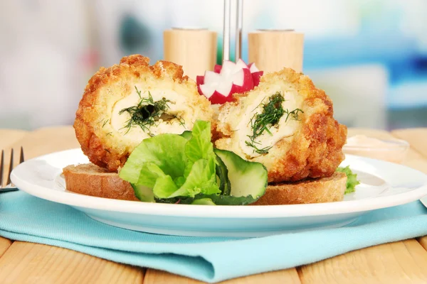 Hühnerkiev auf Croutons mit Salat, auf Holztisch, auf hellem Hintergrund — Stockfoto