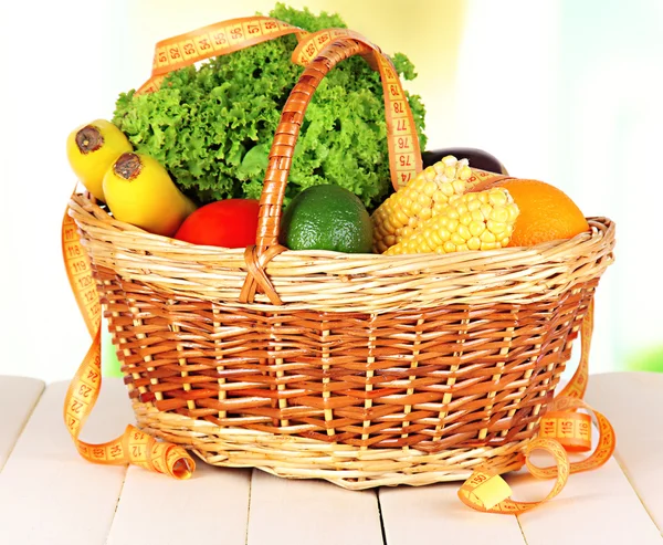 Fresh vegetables in wicker basket on table on light background — Stock Photo, Image