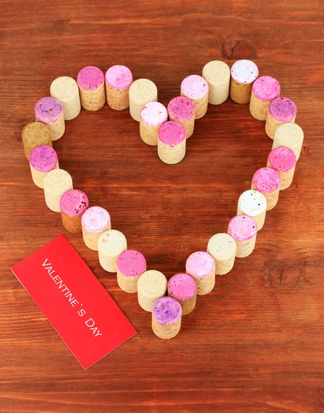 Wine corks laid out in form of heart on wooden table close-up — Stock Photo, Image