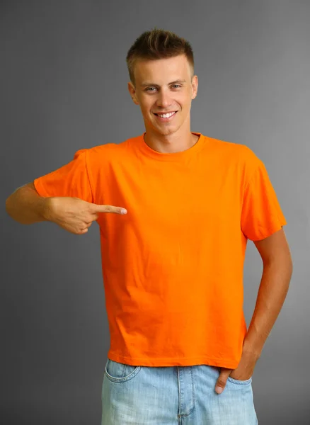 Camiseta sobre hombre joven, sobre fondo gris — Foto de Stock