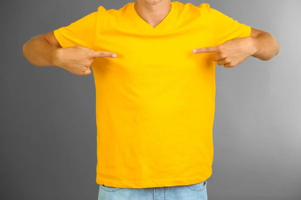 Gri arka plan üzerinde genç erkek t-shirt — Stok fotoğraf