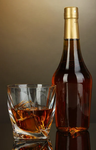 Copo de uísque com garrafa, sobre fundo escuro — Fotografia de Stock