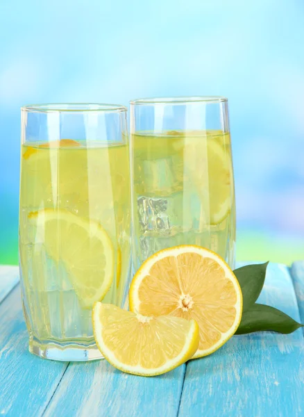 Délicieuse limonade sur table sur fond bleu — Photo