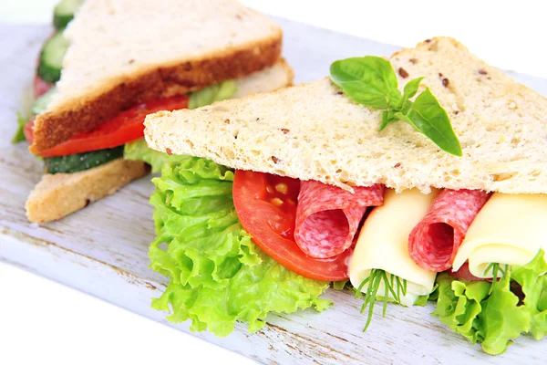 Sanduíches saborosos com salsicha de salame e legumes na tábua de corte, isolados em branco — Fotografia de Stock